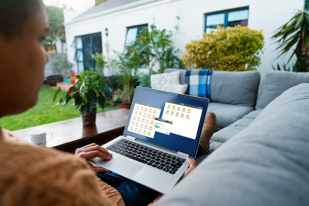 Person sitting outdoors using a laptop for file transfer.