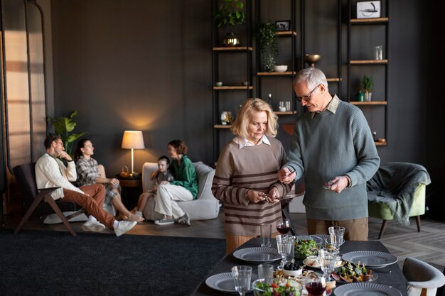 an elderly couple enjoys a meal together in a modern living space, while others relax in the background