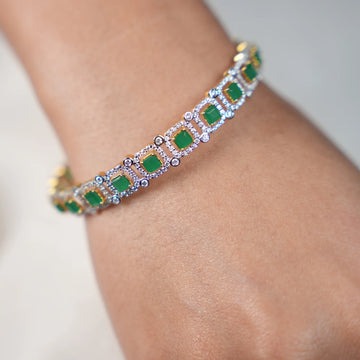 Elegant gold bracelet featuring square green gemstones and diamond accents